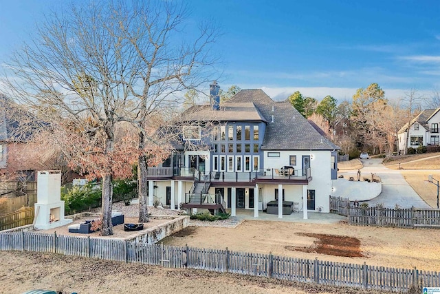 back of house featuring a wooden deck and a patio