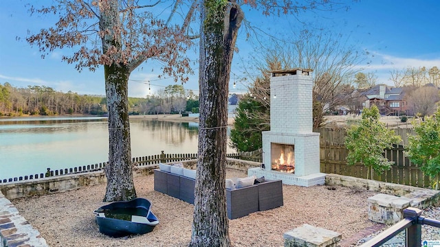 view of patio / terrace with an outdoor brick fireplace and a water view