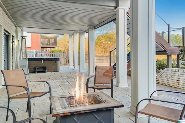 view of patio / terrace featuring a fire pit and a hot tub