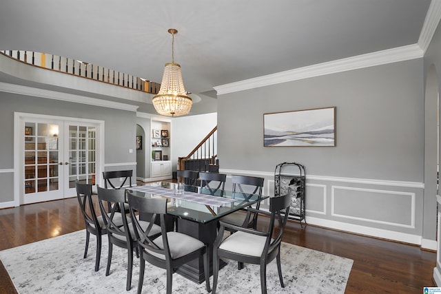 dining area with crown molding, dark wood-type flooring, french doors, and built in shelves