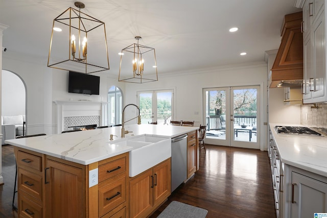 kitchen featuring hanging light fixtures, appliances with stainless steel finishes, a center island with sink, and french doors