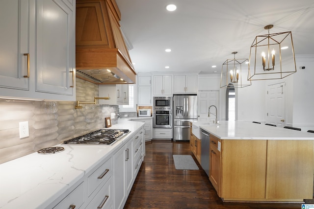 kitchen featuring appliances with stainless steel finishes, light stone countertops, hanging light fixtures, and white cabinets