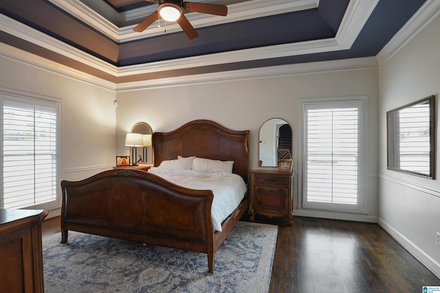 bedroom featuring a tray ceiling, ornamental molding, dark hardwood / wood-style floors, and multiple windows