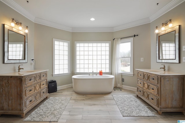 bathroom featuring a washtub, crown molding, wood-type flooring, and a healthy amount of sunlight