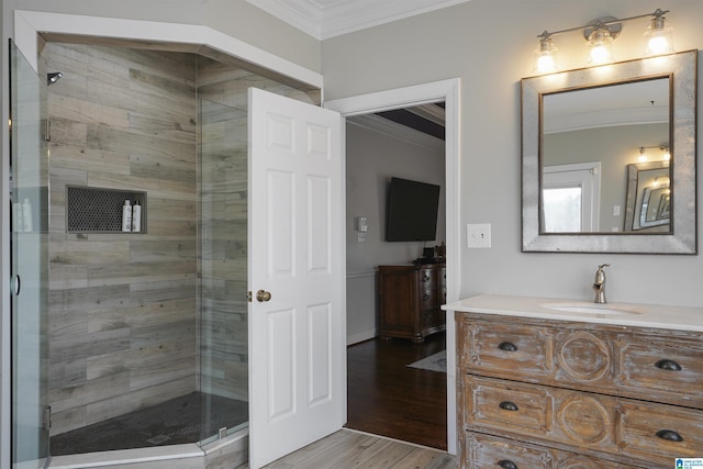 bathroom with vanity, a shower with door, wood-type flooring, and ornamental molding