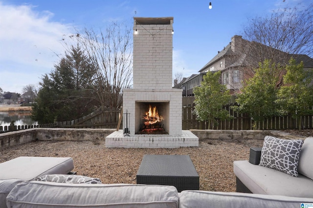 view of patio featuring an outdoor brick fireplace and a water view