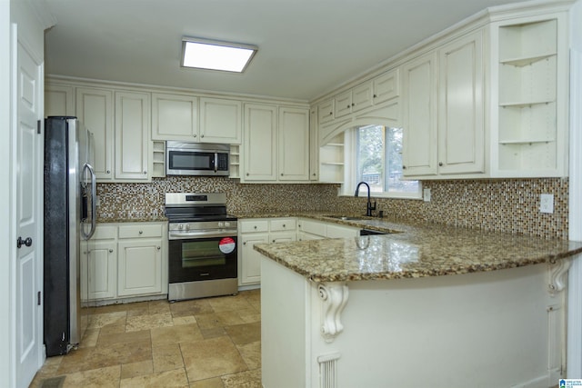 kitchen with sink, light stone counters, white cabinetry, kitchen peninsula, and stainless steel appliances