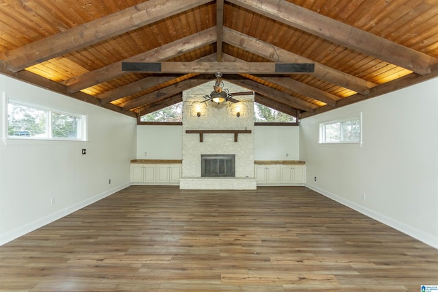 unfurnished living room featuring wood ceiling, a stone fireplace, lofted ceiling with beams, and light wood-type flooring