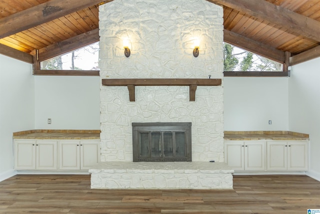 unfurnished living room featuring wood ceiling, a stone fireplace, and vaulted ceiling with beams