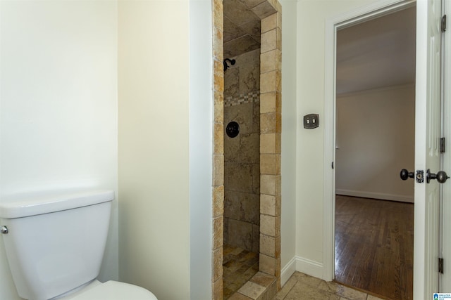 bathroom featuring toilet and a tile shower