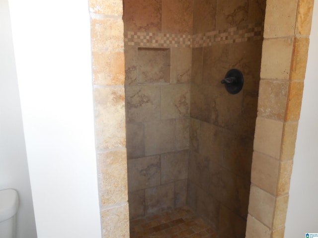 interior details with a tile shower and toilet