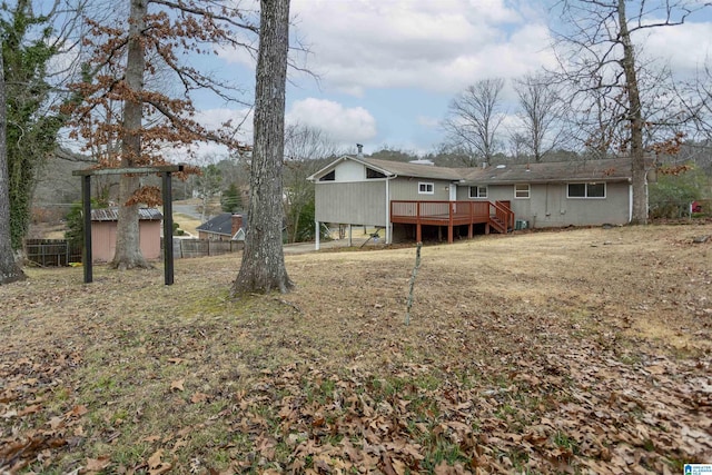 back of house featuring a wooden deck and an outdoor structure