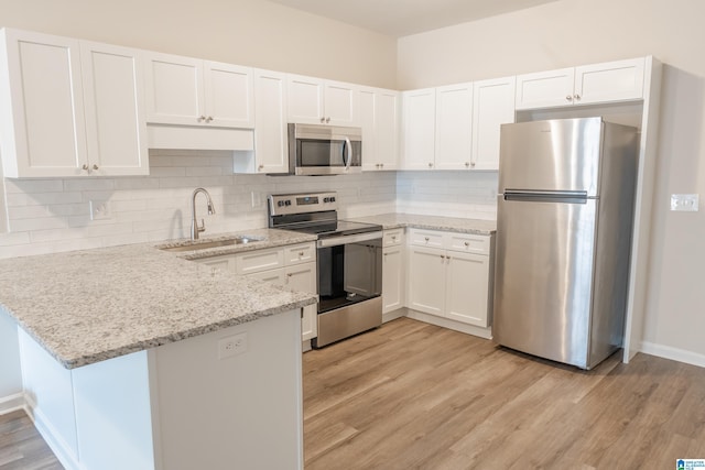 kitchen with sink, stainless steel appliances, light hardwood / wood-style floors, and white cabinets