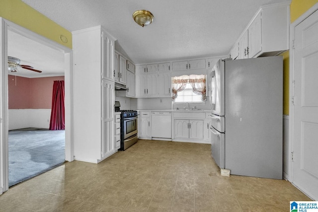 kitchen with stainless steel appliances, white cabinetry, sink, and ceiling fan