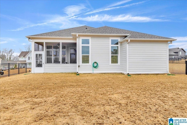 rear view of house featuring a yard and a sunroom