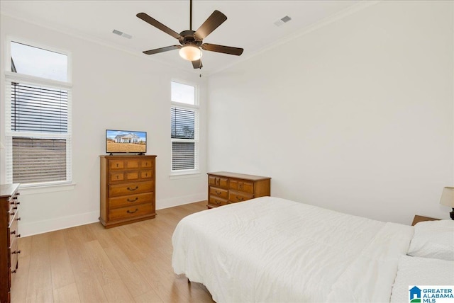 bedroom with ornamental molding, ceiling fan, and light hardwood / wood-style flooring