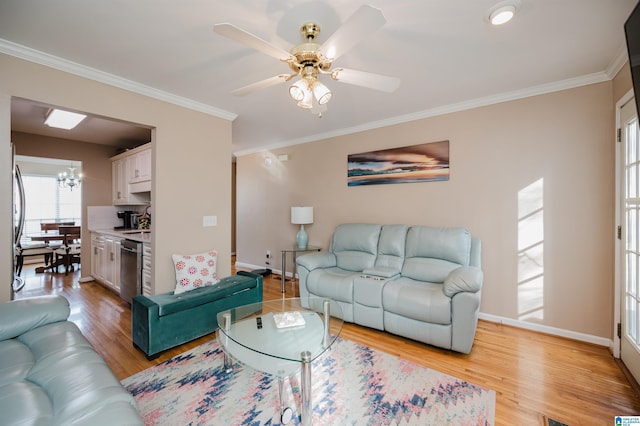 living room featuring crown molding, ceiling fan with notable chandelier, and light wood-type flooring