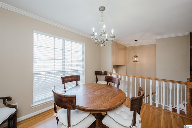 dining space featuring light hardwood / wood-style flooring, ornamental molding, and a chandelier