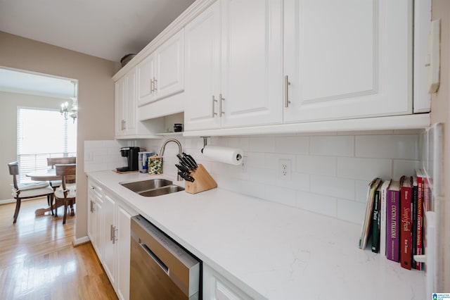 kitchen featuring sink, light hardwood / wood-style flooring, dishwasher, tasteful backsplash, and white cabinets