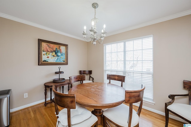 dining area featuring ornamental molding, a notable chandelier, and light wood-type flooring