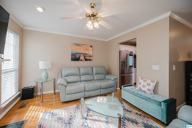 living room featuring light hardwood / wood-style flooring, a wealth of natural light, ornamental molding, and ceiling fan