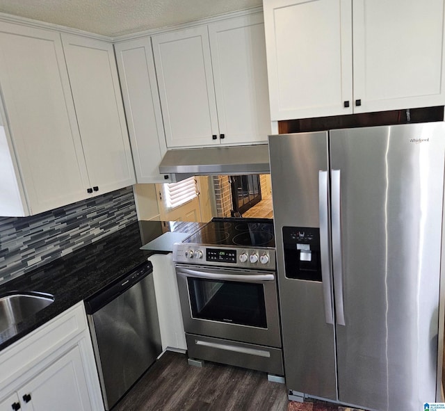 kitchen with sink, dark wood-type flooring, white cabinetry, backsplash, and stainless steel appliances