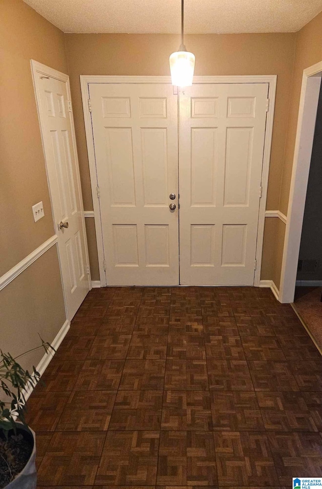 foyer entrance featuring dark parquet flooring