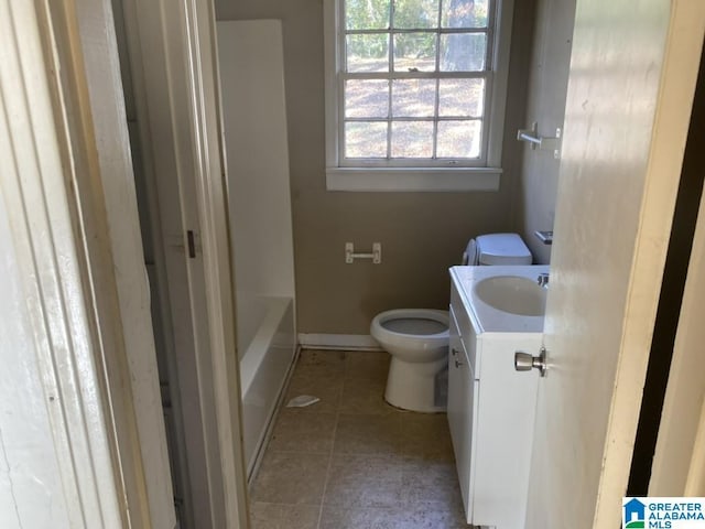 bathroom featuring vanity, toilet, tile patterned flooring, and a washtub