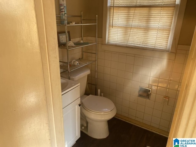 bathroom featuring vanity, tile walls, and toilet