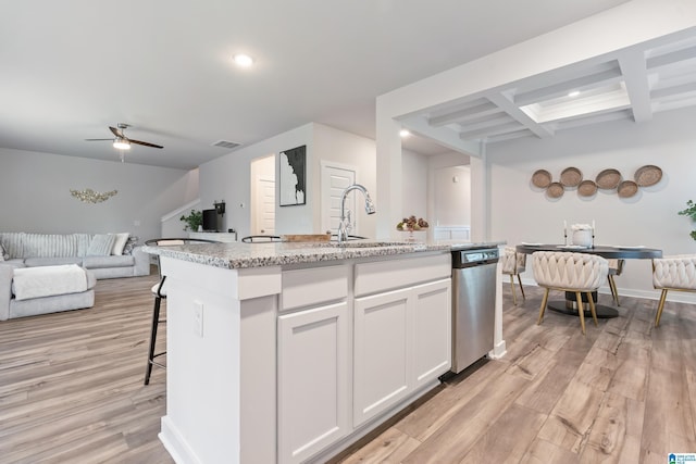 kitchen with sink, light hardwood / wood-style flooring, dishwasher, white cabinets, and a center island with sink