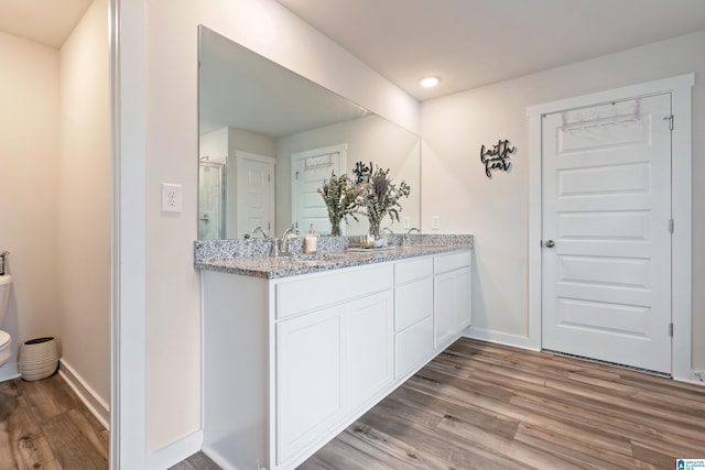 bathroom with vanity, an enclosed shower, and hardwood / wood-style flooring