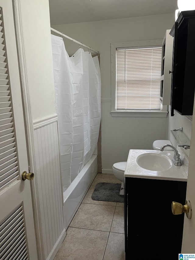 full bathroom with vanity, toilet, tile patterned floors, and shower / bath combo with shower curtain