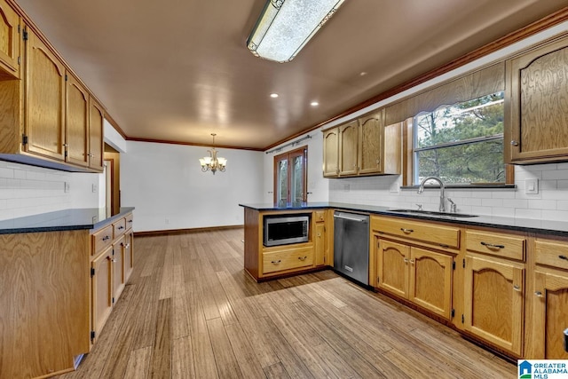 kitchen with sink, light hardwood / wood-style flooring, kitchen peninsula, pendant lighting, and stainless steel appliances