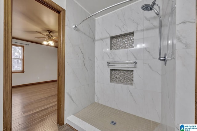 bathroom featuring ceiling fan, crown molding, wood-type flooring, and tiled shower