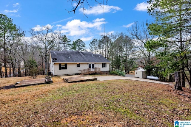 rear view of house with a deck and a lawn