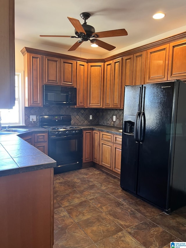 kitchen featuring tasteful backsplash, sink, black appliances, and ceiling fan