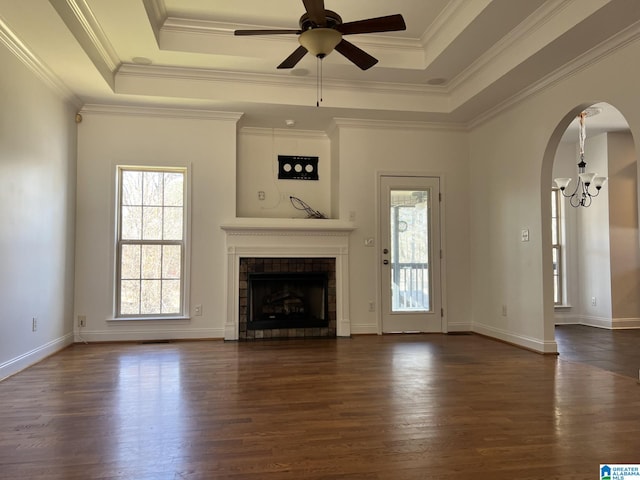 unfurnished living room featuring a tray ceiling, dark hardwood / wood-style flooring, and a wealth of natural light