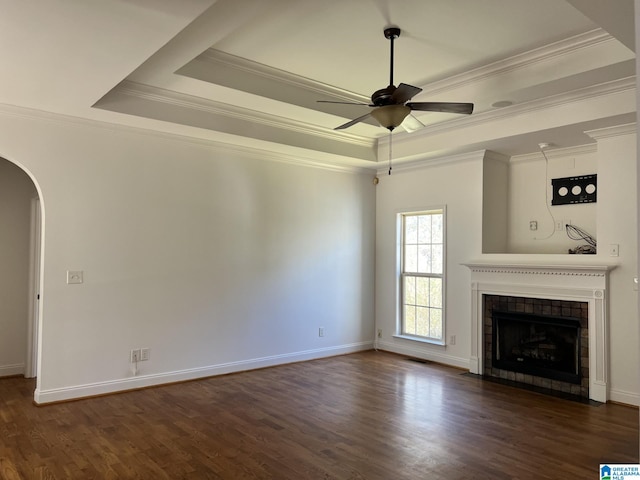 unfurnished living room with dark wood-type flooring, a raised ceiling, and ceiling fan