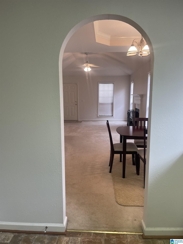 dining space featuring crown molding, ceiling fan, a tray ceiling, and dark carpet