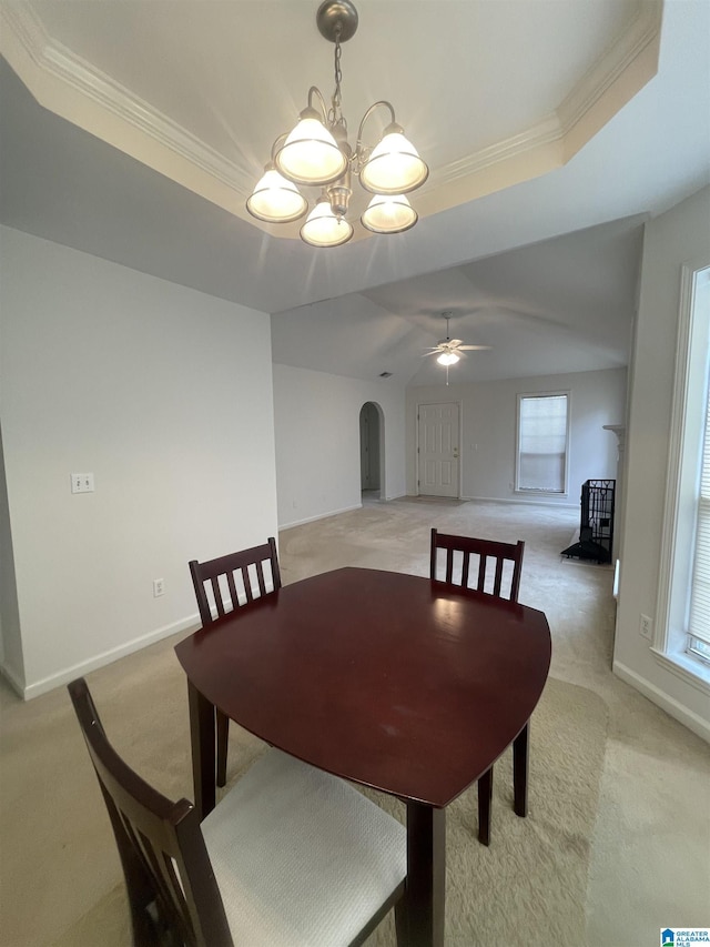 dining room featuring crown molding, light colored carpet, a raised ceiling, and ceiling fan with notable chandelier