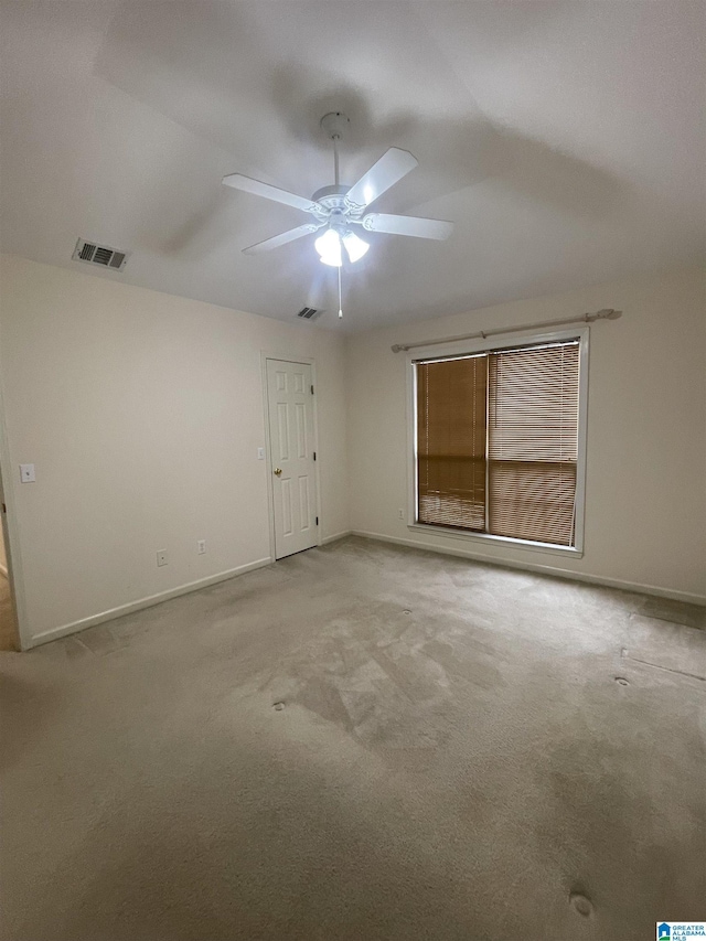 carpeted spare room with ceiling fan