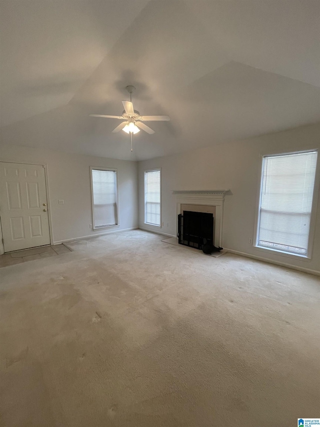 unfurnished living room with lofted ceiling, light colored carpet, and ceiling fan