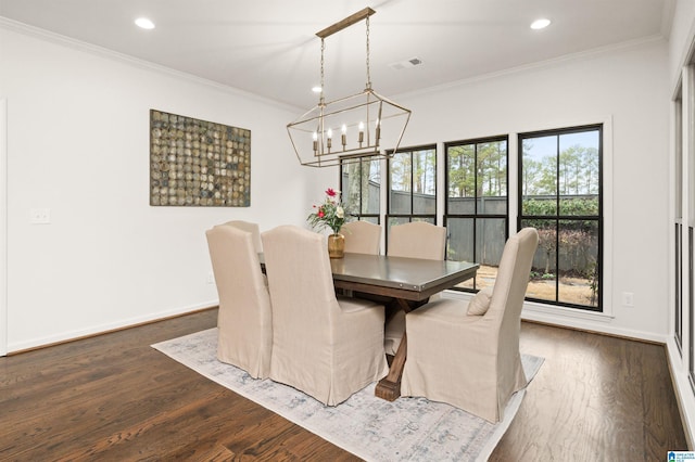 dining space with crown molding, dark wood-type flooring, and a chandelier