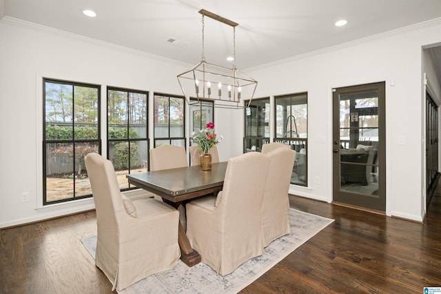 dining space with ornamental molding, an inviting chandelier, and dark hardwood / wood-style flooring