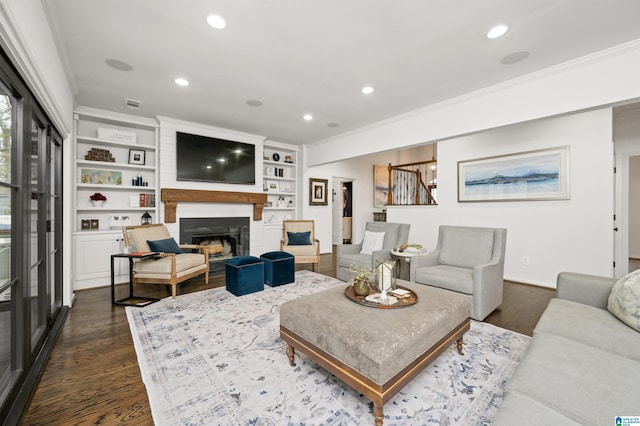 living room with dark wood-type flooring, a fireplace, and ornamental molding