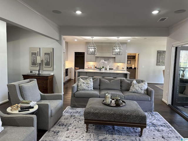 living room featuring crown molding, sink, and dark hardwood / wood-style flooring