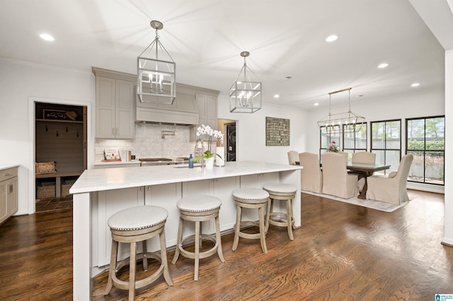 kitchen with pendant lighting, a breakfast bar area, and a large island with sink