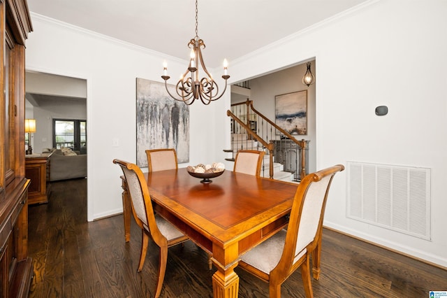 dining room featuring dark wood-type flooring, ornamental molding, and a notable chandelier