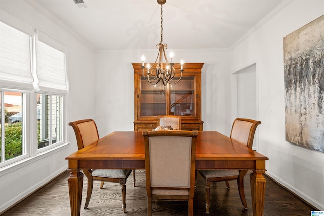 dining room featuring crown molding, dark wood-type flooring, and a chandelier