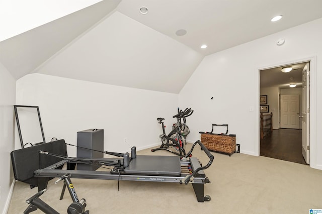 exercise room with lofted ceiling and light carpet